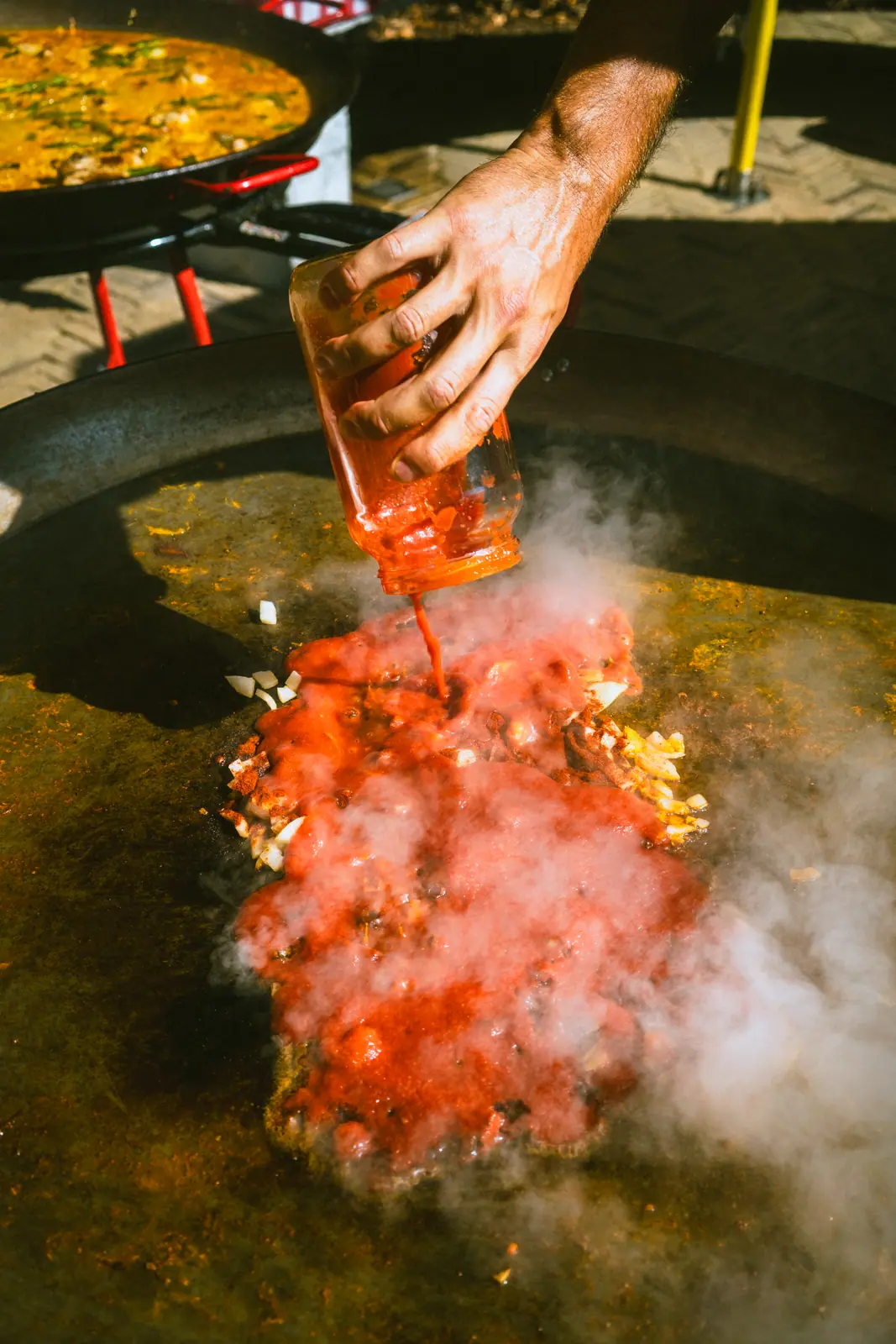 Food photography Zürich — open fire paella with flames and smoke